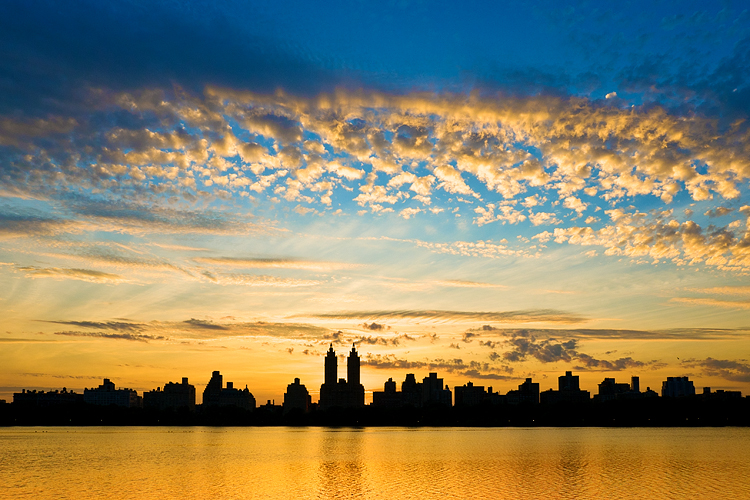 Orange sunset over New York and Central park reservoir