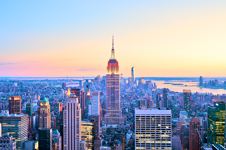 Wide aerial view of New York illuminated at dusk with Empire State Building