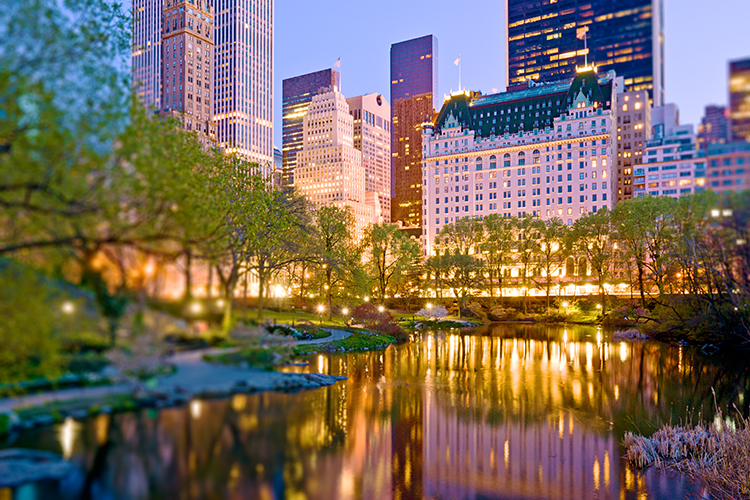 Central Park Pond and the Plaza Hotel illuminated at dusk in spring